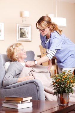 caregiver covering woman  with blanket clipart