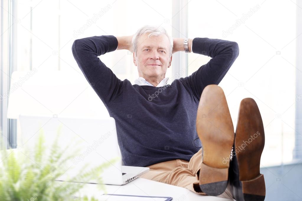 businessman with legs on desk