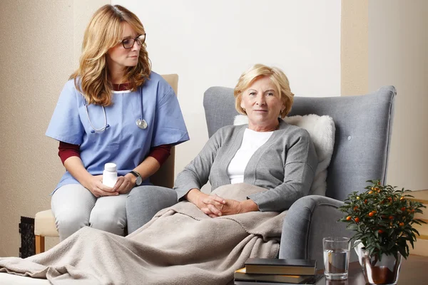 Caregiver sitting with senior patient — Stock Fotó