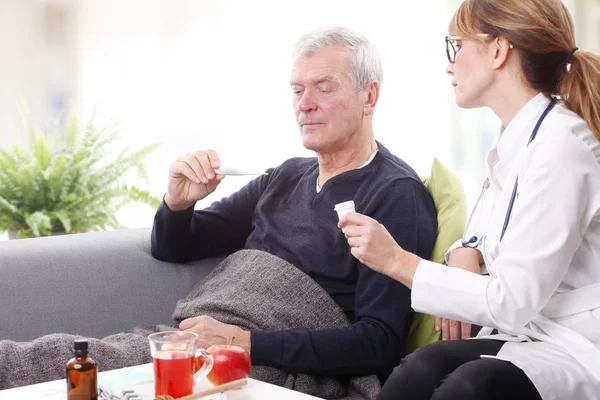 Old patient checking thermometer — Stockfoto