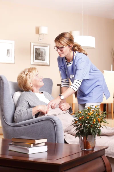 Female nurse covering woman — Stockfoto