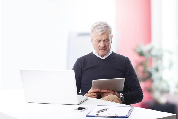 Homem de negócios lendo no tablet digital — Fotografia de Stock