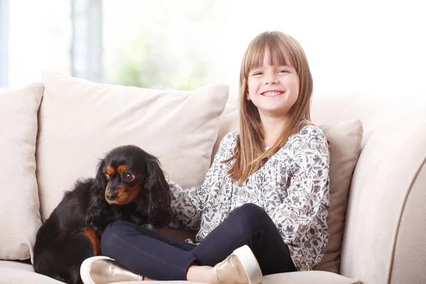 Dívka sedící s její pet na pohovce — Stock fotografie