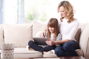 Anne ve kızı tablet kullanıyor.