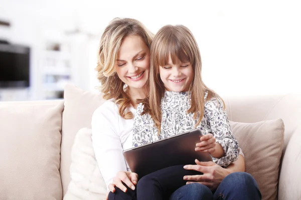 Mother and daughter holding tablet — Stockfoto