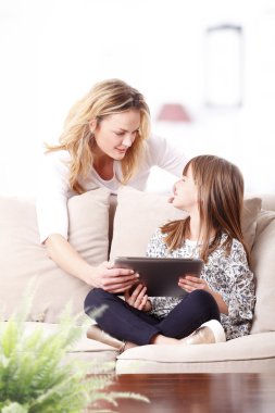 Anne ve kızı tablet kullanıyor.