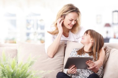 Anne ve kızı tablet kullanıyor.