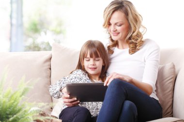 Anne ve kızı tablet kullanıyor.