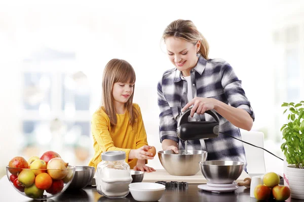 Meisje en haar moeder de ingrediënten mengen. — Stockfoto