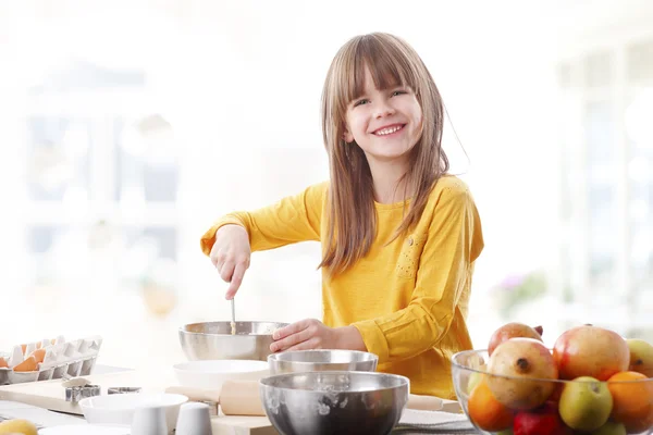 Girl standing in  kitchen and cooking. — Stockfoto