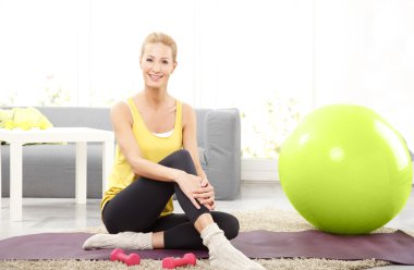 bir yoga mat üzerinde oturan kadın