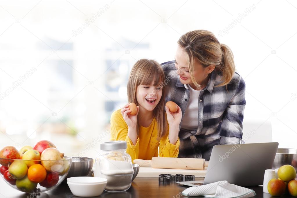 mother and  daughter using laptop