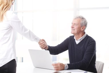 İş adamı iş kadınıyla tokalaşıyor