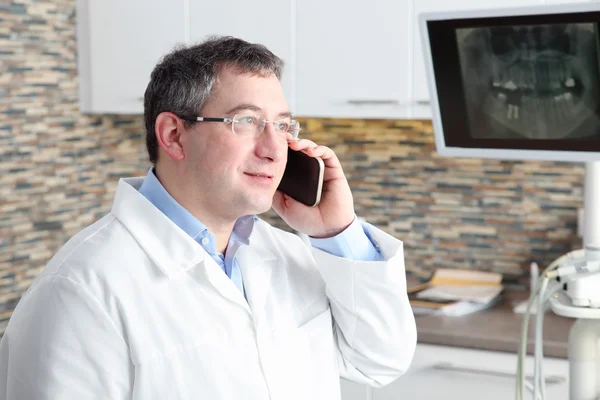 Стоматолог-за допомогою мобільного — стокове фото