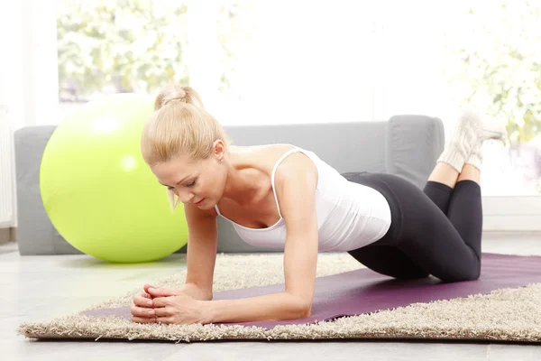 Vrouw die thuis yoga doet. — Stockfoto