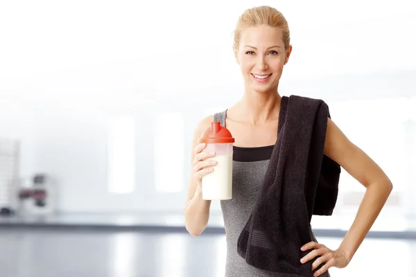 Kadın bir protein shaker tutan bir havlu ile — Stok fotoğraf