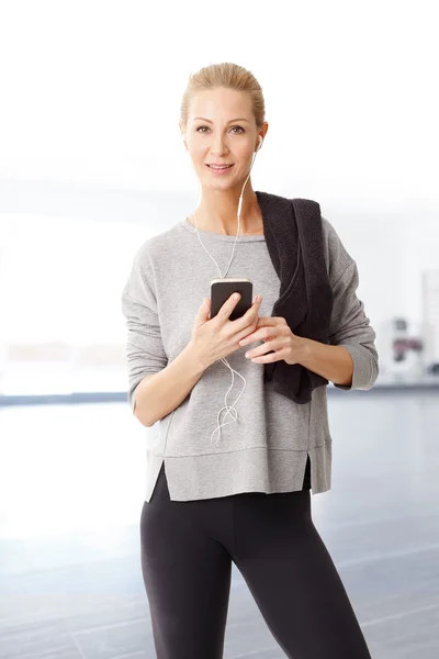 Donna con un asciugamano in possesso di telefono cellulare — Foto Stock