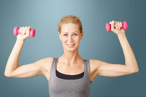 Mujer rubia haciendo ejercicio con pesas — Foto de Stock
