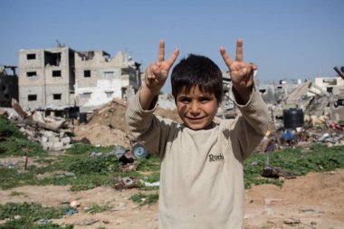 Gaza Strip, children play and live on the street amidst the rubble after the bombings clipart