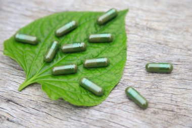 Günlük hayatta sağlıklı beslenmek için yeşil bitkinin yapraklı kapsülleri. Su teresinden kapsüller.
