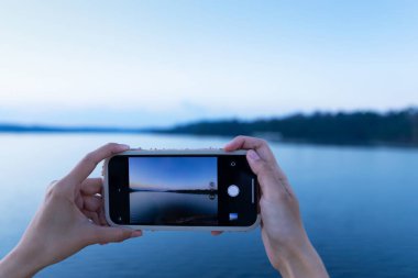 Boş zamanlarında dinlenmek için el ele tutuşan bir kız el ele tutuşup doğaya bakıyor.