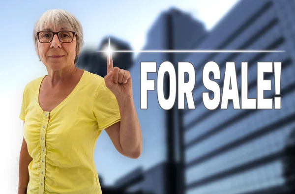 For sale touchscreen is shown by Senior Woman background — Stock Photo, Image