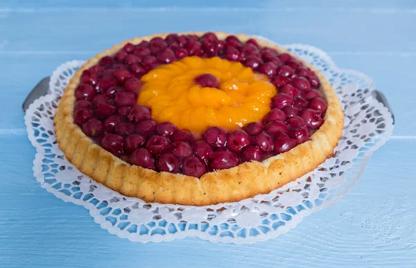 meyveli kek kiraz ve mavi ahşap üzerine mandalina ile