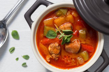 Gulaş ile mercanköşk beyaz tahta üzerinde siyah bir cocotte