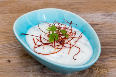 yoğurt bitki daldırma ile ahşap arka plan üzerinde kırmızı biber iplik