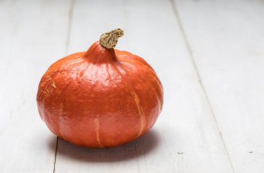 Kopya alanı olan beyaz ahşap zemin üzerinde balkabağı 