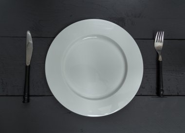 Çatal bıçak takımı ve plaka siyah ahşap zemin