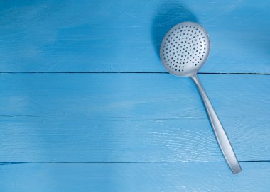 arka plan olarak mavi ahşap üzerine oluklu kaşık