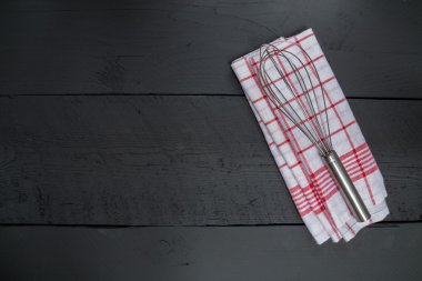 Çırpma teli ve siyah ahşap zemin üzerine çay havlu