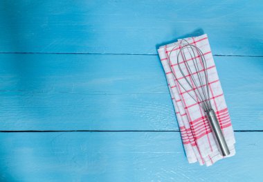 Çırpma teli ve çay havlu mavi ahşap zemin üzerine