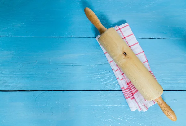 Rolling pin e strofinaccio su sfondo blu in legno — Foto Stock