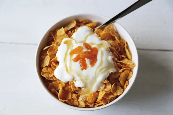 Płatki kukurydziane w misce z jogurtu i miodu — Zdjęcie stockowe
