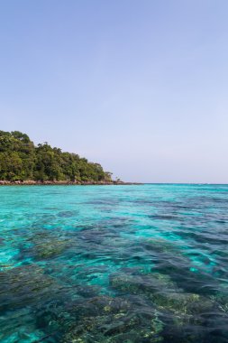 Cristal mavi deniz mavi gökyüzü altında