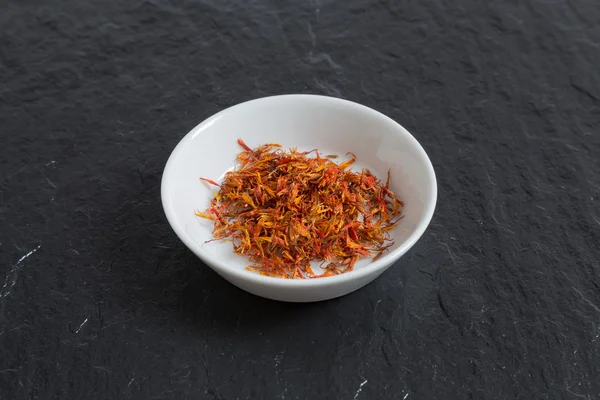 Saffron in a bowl on a slate — Stock Photo, Image