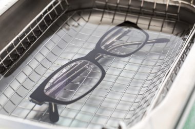 Professional cleaning glasses with an ultrasonic cleaner clipart