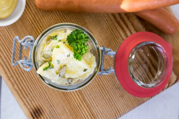 Kartoffelsalat im Glas auf Holzbrett — Stockfoto