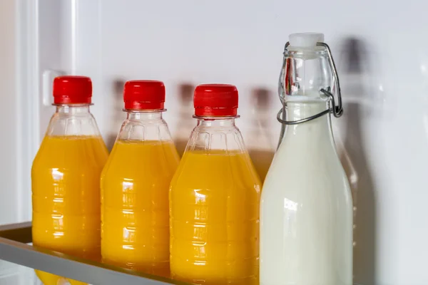 Öppna kylen fylld med orange juice och mjölk — Stockfoto