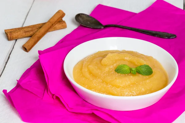 Applesauce on pink paper and spoon — Stock Photo, Image