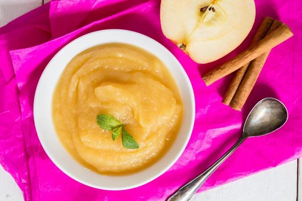 Applesauce on pink paper and spoon — Stock Photo, Image