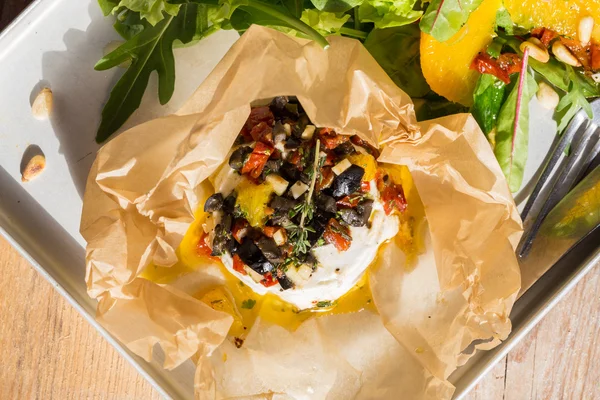 Baked goat cheese Mediterranean in parchment paper — Stock Photo, Image