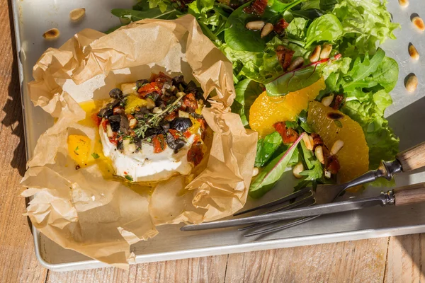 Baked goat cheese Mediterranean in parchment paper — Stock Photo, Image