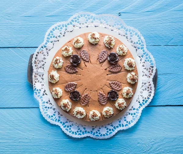 Schokoladencremetorte auf blauem Holz mit Kuchenspitze — Stockfoto