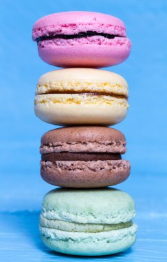 Colorful macarons on a blue wooden macro clipart