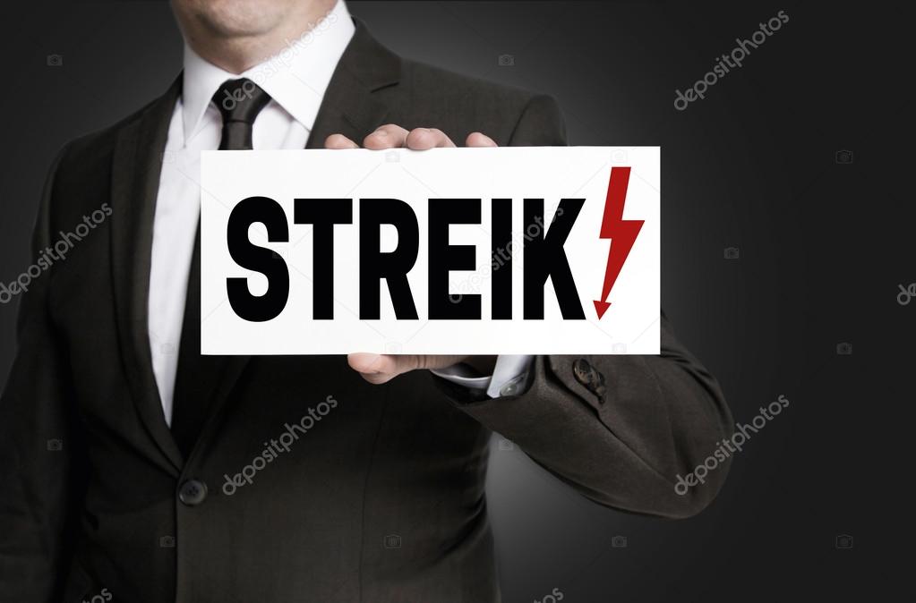 Strike sign is held by businessman