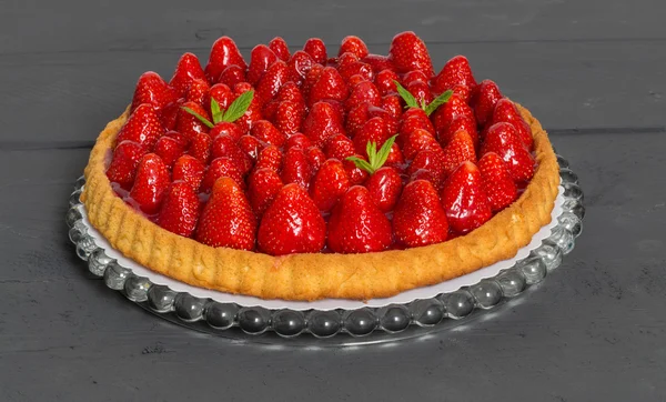 Gâteau aux fraises aux feuilles de menthe sur un bois anthracite — Photo