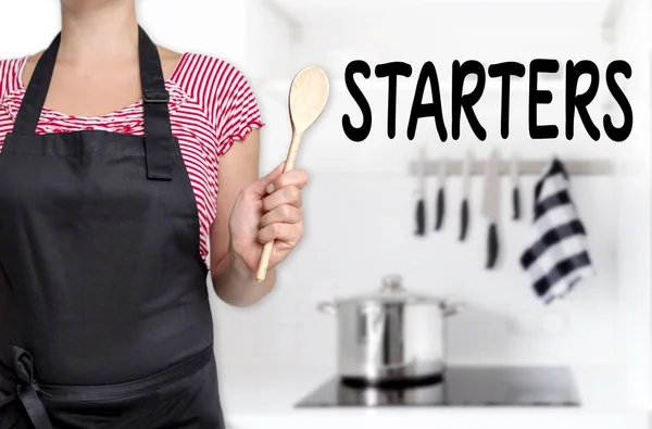 Arrancadores cocinero celebración de fondo cuchara de madera — Foto de Stock